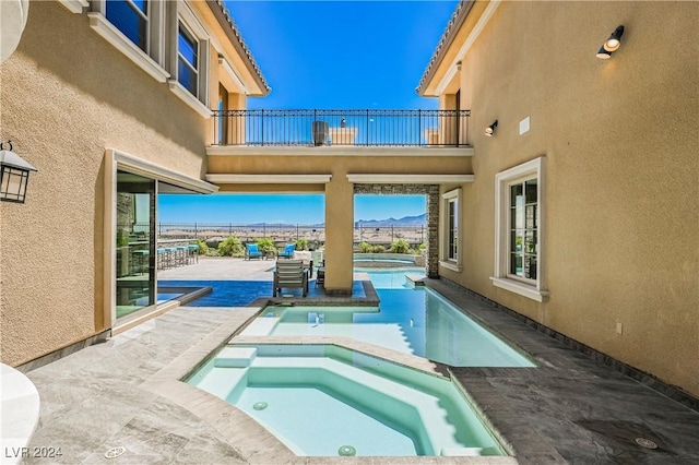 view of swimming pool with an in ground hot tub and a patio