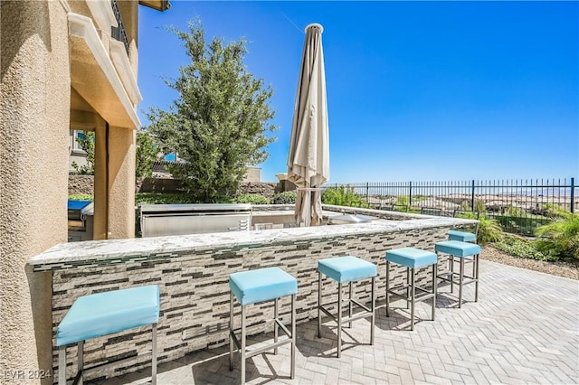 view of patio / terrace featuring a water view and a bar