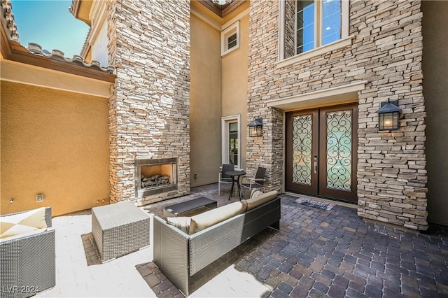 view of patio featuring an outdoor living space with a fireplace and french doors