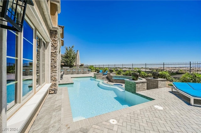 view of pool featuring a patio area and an in ground hot tub