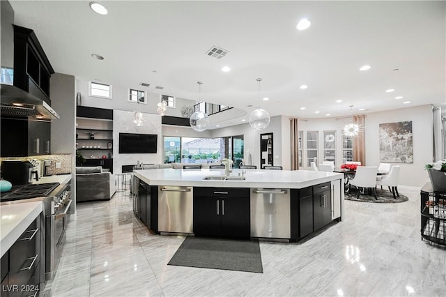 kitchen with a large island, sink, hanging light fixtures, exhaust hood, and appliances with stainless steel finishes