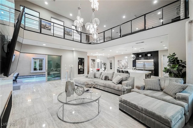 living room with a towering ceiling and a chandelier