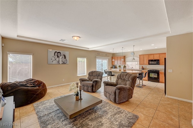 tiled living room featuring a textured ceiling and a tray ceiling