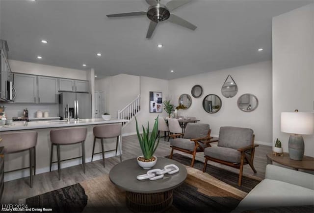 living room with sink, dark wood-type flooring, and ceiling fan