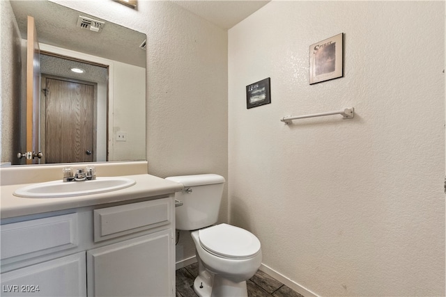 bathroom featuring vanity, hardwood / wood-style flooring, and toilet