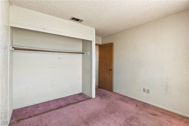 unfurnished bedroom with a closet, carpet floors, and a textured ceiling