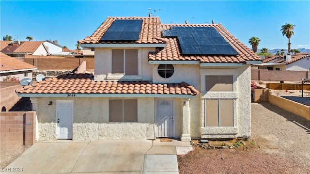 view of front of home with a patio area and solar panels