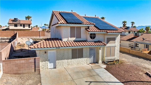 view of front of house with solar panels and a patio