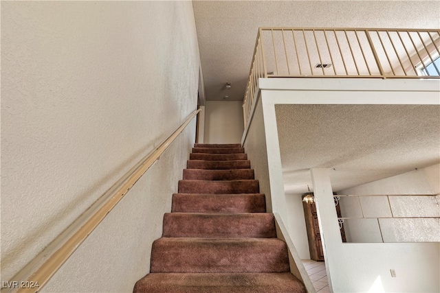 staircase featuring a textured ceiling