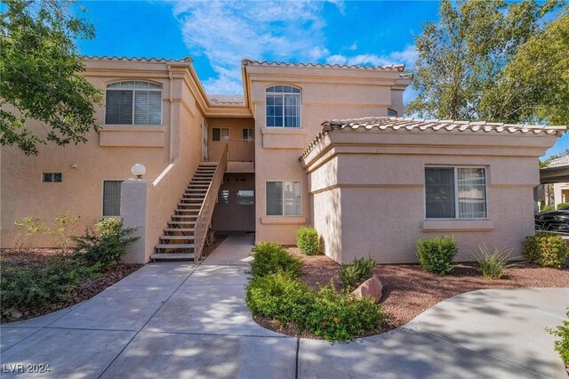 7400 W Flamingo Rd Unit 2013, Las Vegas, NV 89147 - view of front of house featuring stucco siding, a tile roof, and stairs