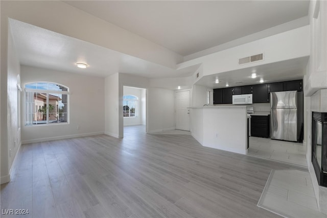 kitchen with light wood-type flooring and stainless steel fridge