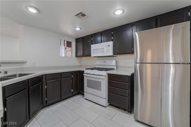 kitchen featuring a textured ceiling, sink, and white appliances