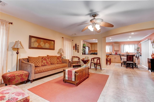 tiled living room with ceiling fan