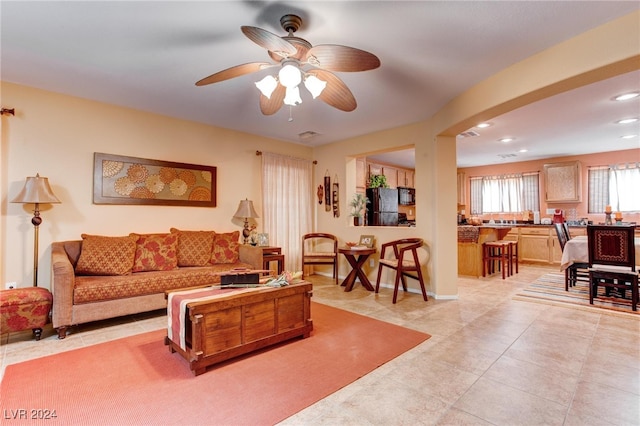 living room featuring light tile patterned floors and ceiling fan