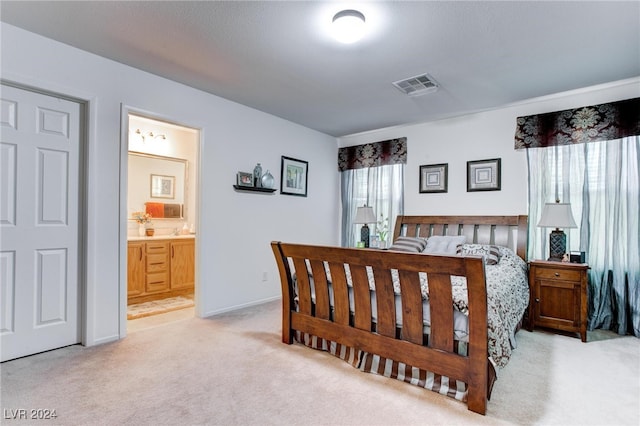 carpeted bedroom featuring ensuite bathroom and multiple windows