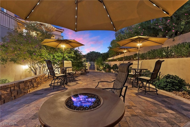 patio terrace at dusk featuring an outdoor fire pit