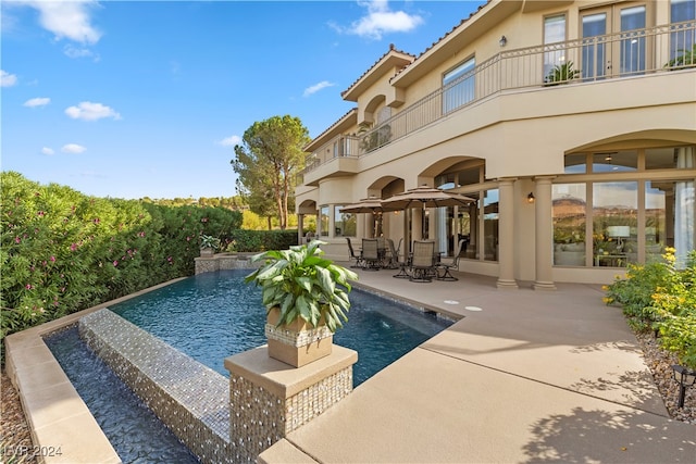 view of pool with pool water feature and a patio area