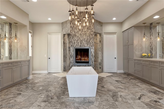 bathroom featuring vanity, a bathing tub, and a fireplace