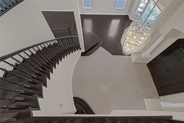 stairs featuring a high ceiling, a chandelier, and tile walls