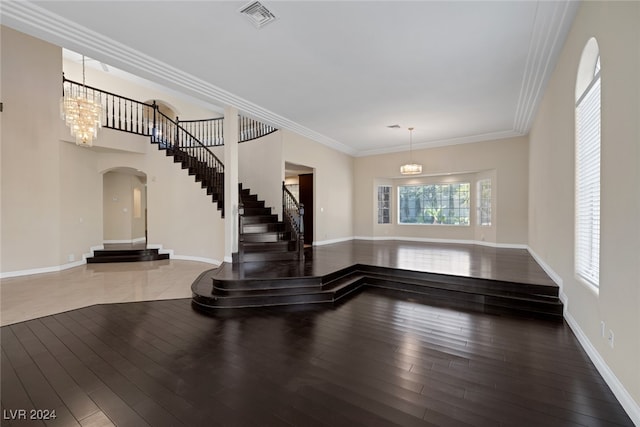 entrance foyer with a chandelier, hardwood / wood-style floors, and ornamental molding