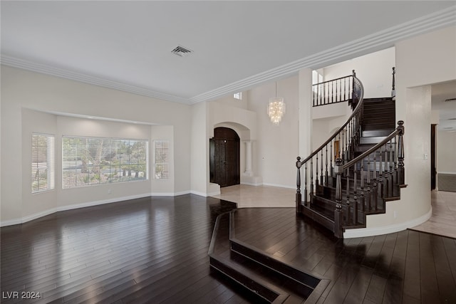 foyer with a chandelier, hardwood / wood-style flooring, and crown molding