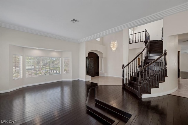 1931 Fox Canyon Cir, Las Vegas, NV 89117 - foyer featuring arched walkways, wood finished floors, crown molding, stairway, and baseboards