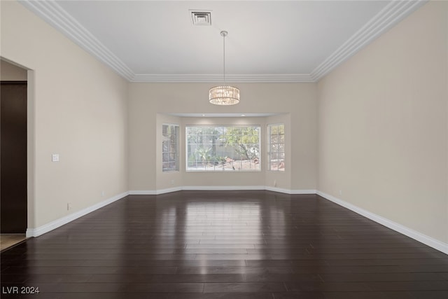 unfurnished dining area featuring dark wood-type flooring, an inviting chandelier, and crown molding