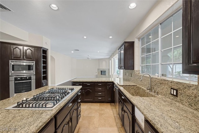 1931 Fox Canyon Cir, Las Vegas, NV 89117 - kitchen with appliances with stainless steel finishes, a sink, decorative backsplash, dark brown cabinets, and recessed lighting