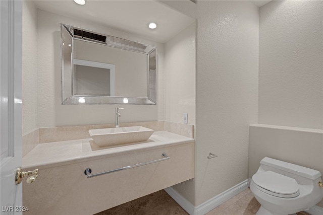 bathroom featuring vanity, tile patterned floors, and toilet