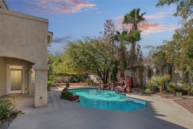 pool at dusk with a patio