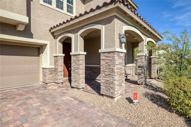 6370 Ava Ridge Ave, Las Vegas, NV 89141 - view of exterior entry featuring stucco siding, a tile roof, and a garage