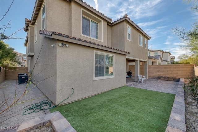 rear view of house with a patio, central AC, and a yard