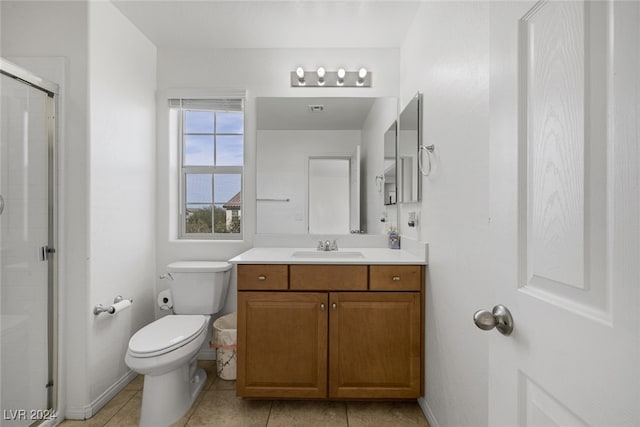 bathroom featuring toilet, walk in shower, vanity, and tile patterned floors