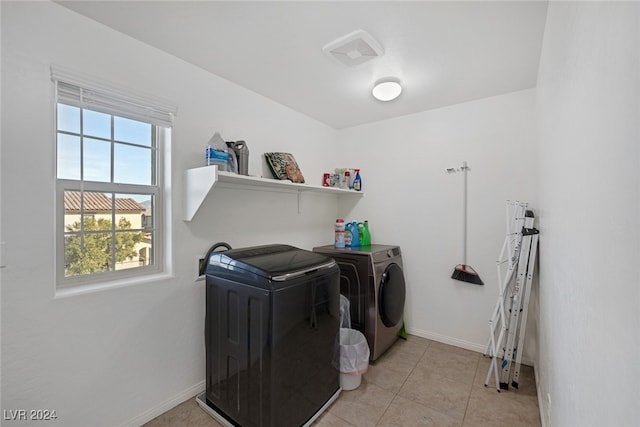 laundry area featuring washer and clothes dryer and light tile patterned flooring