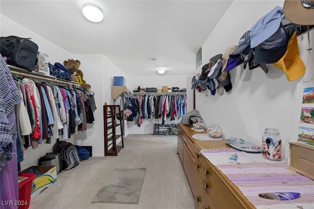 spacious closet featuring light colored carpet