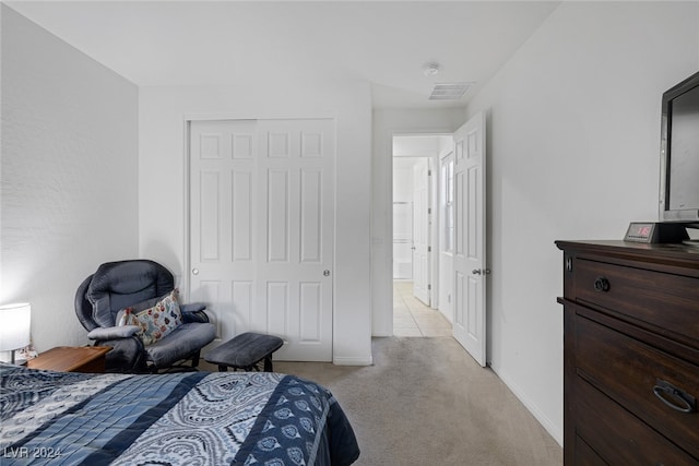 bedroom featuring a closet and light colored carpet