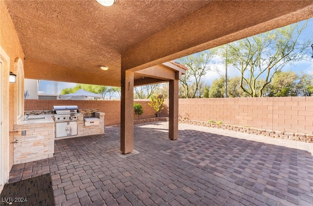 view of patio with area for grilling and sink