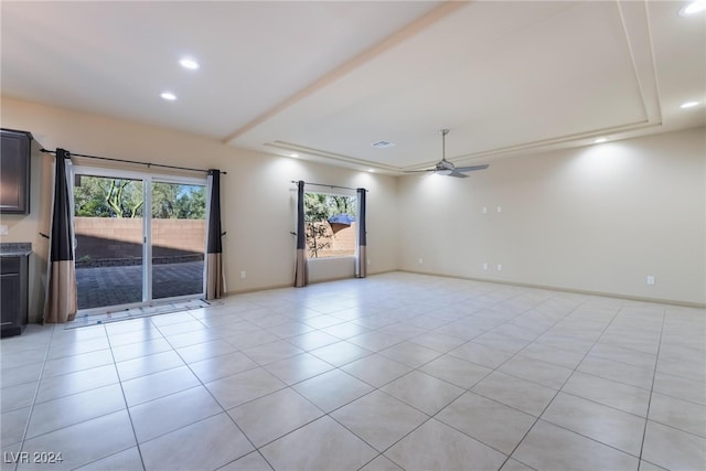 tiled empty room with ceiling fan and a wealth of natural light