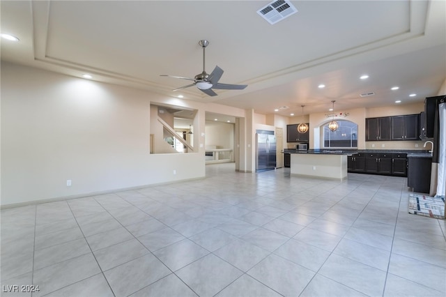 unfurnished living room featuring light tile patterned floors, a raised ceiling, and ceiling fan