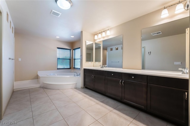 bathroom featuring a bathing tub, vanity, and tile patterned flooring