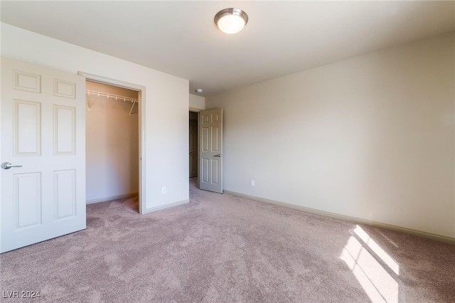 unfurnished bedroom with a closet and light colored carpet