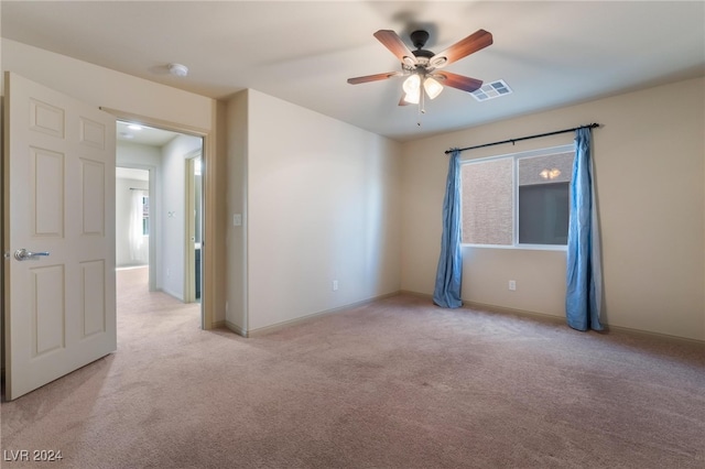 empty room featuring light colored carpet and ceiling fan