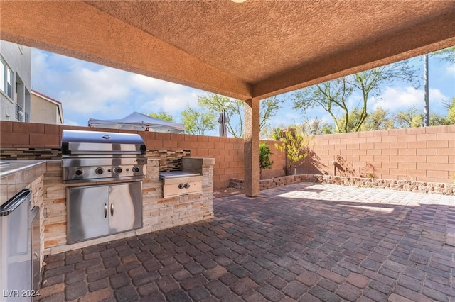 view of patio with area for grilling and an outdoor kitchen