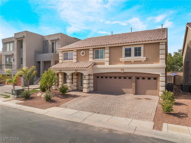 view of front of property featuring central AC and a garage