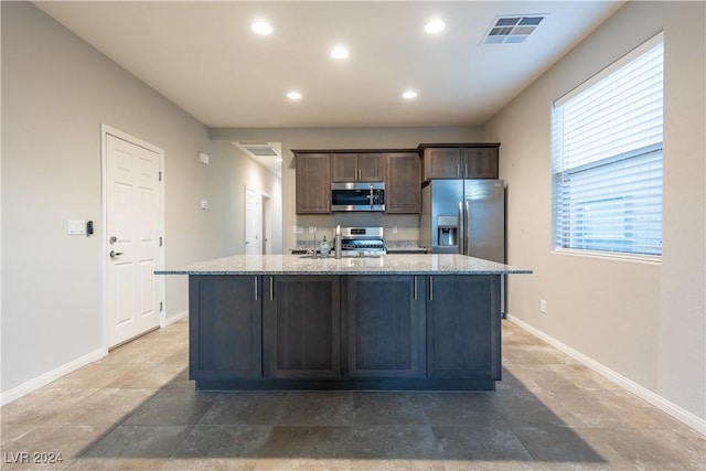 2664 Chinaberry Hill St, Laughlin, NV 89029 - kitchen with stainless steel appliances, recessed lighting, baseboards, a center island with sink, and light stone countertops