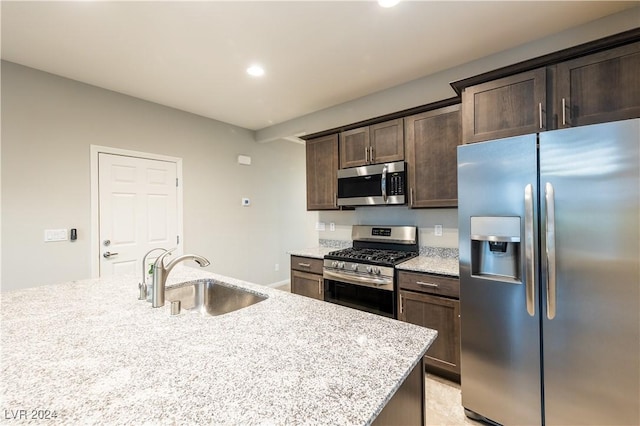 2664 Chinaberry Hill St, Laughlin, NV 89029 - kitchen with stainless steel appliances, a sink, dark brown cabinets, recessed lighting, and light stone counters