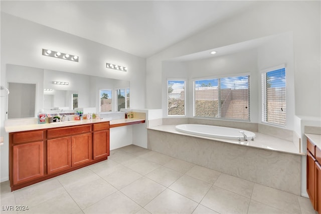 bathroom with vanity, lofted ceiling, a washtub, and tile patterned flooring