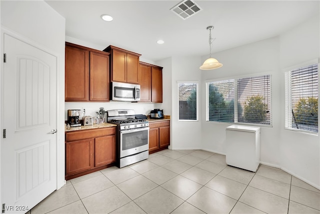 kitchen featuring hanging light fixtures, stainless steel appliances, and light tile patterned floors