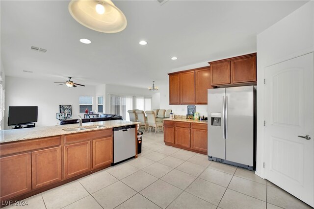 kitchen with appliances with stainless steel finishes, sink, ceiling fan, light stone counters, and light tile patterned floors