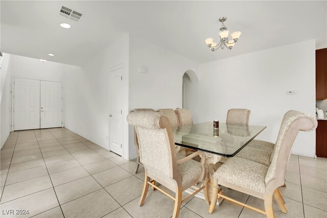 dining area with light tile patterned floors and an inviting chandelier